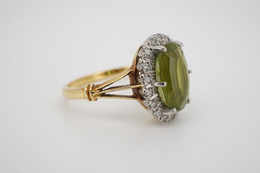 An 18ct, peridot and diamond set oval cluster ring, size K/L, gross weight 4.1 grams. Condition - poor to fair